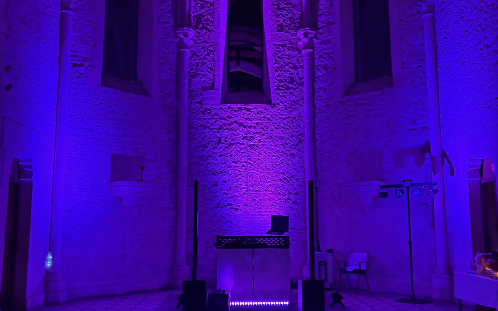 Sonorisation et éclairage violet installés dans la nef d'une église pour une cérémonie