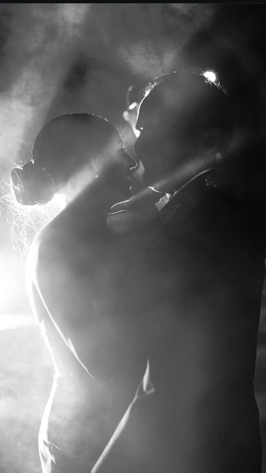 Première danse des mariés à contre-jour dans la fumée, en noir et blanc