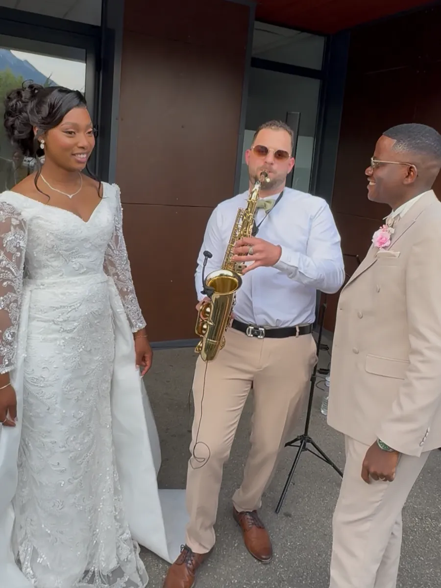 Les mariés écoutant Saxotriss jouer du saxophone à leur sortie de cérémonie