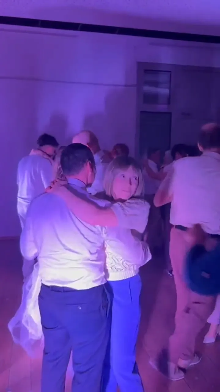 Les invités dansent autour des mariés pendant l'ouverture de bal